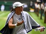 Poland's Iga Swiatek speaks to her team after loosing her first set against Ukraine's Elina Svitolina during their women's singles quarter-finals tennis match on the ninth day of the 2023 Wimbledon Championships