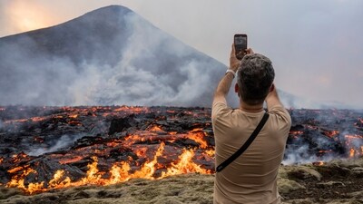 A man takes pictures as lava emerges from a fissure of the Fagradalsfjall volcano near the Litli-Hrútur mountain, some 30 kilometers (19 miles) southwest of Reykjavik, Iceland, Monday July 10, 2023. Authorities in Iceland on Tuesday warned spectators to stay away from a newly erupting volcano that is spewing lava and noxious gases from a fissure in the country’s southwest (AP Photo/Marco Di Marco) A man takes pictures as lava emerges from a fissure of the Fagradalsfjall volcano near the Litli-Hrútur mountain, some 30 kilometers (19 miles) southwest of Reykjavik, Iceland, Monday July 10, 2023. Authorities in Iceland on Tuesday warned spectators to stay away from a newly erupting volcano that is spewing lava and noxious gases from a fissure in the country’s southwest (AP Photo/Marco Di Marco)