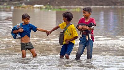 People from low-lying areas around the Yamuna river carry their belongings while relocating to a safer place near Old Yamuna Bridge in New Delhi on Tuesday. (Sanjeev Verma/HT Photo)