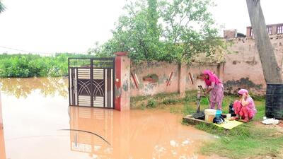 Residents of Phillaur outside their houses amid rise in water levels following heavy rainfall in Jalandhar. (ANI Photo)