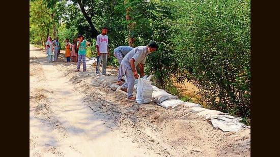 Residents of Bholewal village fortifying the banks along the Sutlej in Ludhiana on Tuesday. (MANISH/HT)