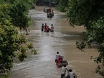 Residents carry their belongings on rickshaws through a street flooded with the rising water level of river Yamuna after heavy monsoon rains in New Delhi.(Reuters)