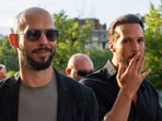 Andrew Tate, left, and his brother Tristan pose with a man outside the Court of Appeal in Bucharest, Romania.