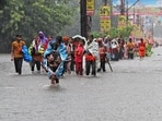 Kanwariyas, the devotees of Hindu god Shiva, carry holy water from river Ganges as they walk through a flooded street during their 'Kanwar Yatra' pilgrimage after heavy rains in Haridwar, in India's Uttarakhand state. 
