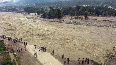 Locals walk along the eroded riverbank damaged by the swollen Beas river following heavy monsoon rains in Himachal Pradesh. (PTI Photo)