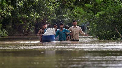 People from low-lying areas around the Yamuna River wade through floodwaters of the swollen river while relocating to a safer place, in New Delhi, Wednesday, July 12, 2023. (PTI Photo)(PTI07_12_2023_000260B) (PTI) People from low-lying areas around the Yamuna River wade through floodwaters of the swollen river while relocating to a safer place, in New Delhi, Wednesday, July 12, 2023. (PTI Photo)(PTI07_12_2023_000260B) (PTI)