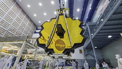 In this photo provided by NASA, technicians lift the mirror of the James Webb Space Telescope using a crane, (AP) In this photo provided by NASA, technicians lift the mirror of the James Webb Space Telescope using a crane, (AP)