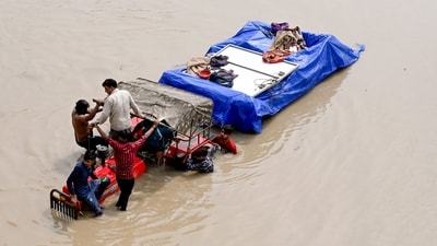 People move to a safe place as flood water levels rise at the banks of Yamuna river, near Mayur Vihar in New Delhi on Wednesday. (ANI)