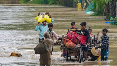 People from low-lying areas around the Yamuna river wade through floodwaters of the swollen river while relocating to a safer place, in New Delhi, Wednesday, July 12, 2023. (PTI) People from low-lying areas around the Yamuna river wade through floodwaters of the swollen river while relocating to a safer place, in New Delhi, Wednesday, July 12, 2023. (PTI)