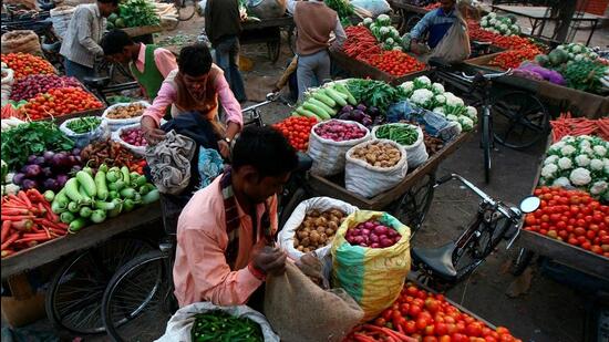 Vendors arrange vegetables on their carts at a wholesale vegetable market (Reuters File Photo)