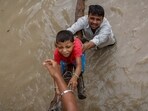 A man helps his son to climb onto a flyover under construction, after being displaced by the rising water level of river Yamuna after heavy monsoon rains in New Delhi. (Reuters)