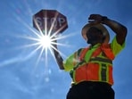 TOPSHOT - Traffic warden Rai Rogers mans his street corner during an 8-hour shift under the hot sun in Las Vegas, Nevada on July 12, 2023, where temperatures reached 106 degrees amid an ongoing heatwave. More than 50 million Americans are set to bake under dangerously high temperatures this week, from California to Texas to Florida, as a heat wave builds across the southern United States. (Photo by Frederic J. BROWN / AFP)