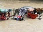 Rickshaw pullers take rest on their rickshaw amid the flood water at Yamuna Bazar area, in New Delhi on Thursday. Rickshaw pullers take rest on their rickshaw amid the flood water at Yamuna Bazar area, in New Delhi on Thursday.