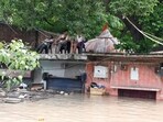 People sit above a rooftop amid the flood water at Yamuna Bazar area, in New Delhi on Thursday. People sit above a rooftop amid the flood water at Yamuna Bazar area, in New Delhi on Thursday.