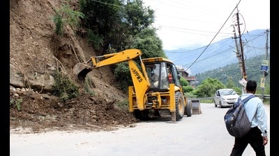 Employees of the PWD department engaged in repair work on Manali-Chandigarh highway on Thursday. (Aqil Khan/HT)