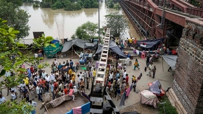 Flood hit people take shelter near a bridge as the swollen Yamuna river floods low-lying areas, in New Delhi, Thursday, (PTI) Flood hit people take shelter near a bridge as the swollen Yamuna river floods low-lying areas, in New Delhi, Thursday, (PTI)