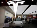Visitors check a Tesla Model 3 car next to a Model Y displayed at a showroom of the U.S. electric vehicle (EV) maker in Beijing, China.