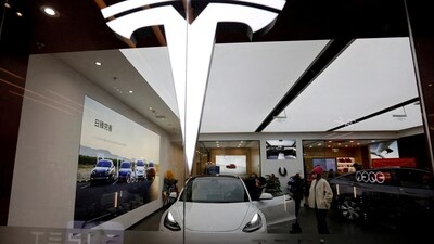 Visitors check a Tesla Model 3 car next to a Model Y displayed at a showroom of the U.S. electric vehicle (EV) maker in Beijing, China. (REUTERS)