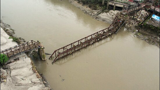 A bridge near Panchvaktra Temple gets damaged due to the rise in the water level of the Beas River triggered by heavy rainfall, in Mandi on Friday. (ANI)