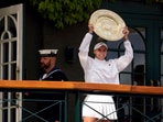 Czech Republic's Marketa Vondrousova celebrates as she shows the trophy from the balcony of Centre Court after beating Tunisia's Ons Jabeur to win the final of the women’s singles on day thirteen of the Wimbledon tennis championships