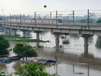 A Delhi Metro train passes by as the swollen Yamuna river floods low-lying areas, in New Delhi, Wednesday. A Delhi Metro train passes by as the swollen Yamuna river floods low-lying areas, in New Delhi, Wednesday.