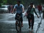 Commuters on road as rains lashed Noida on Saturday. Commuters on road as rains lashed Noida on Saturday.