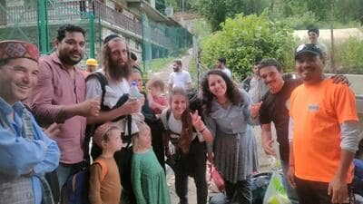 Israeli tourists posing with local residents after they were rescued from Kasol village in the flood-hit Kullu district on Saturday. (HT Photo) Israeli tourists posing with local residents after they were rescued from Kasol village in the flood-hit Kullu district on Saturday. (HT Photo)