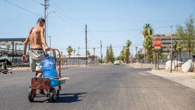 A person transports water jugs through a neighborhood in Phoenix, Arizona. (Getty Images via AFP) A person transports water jugs through a neighborhood in Phoenix, Arizona. (Getty Images via AFP)