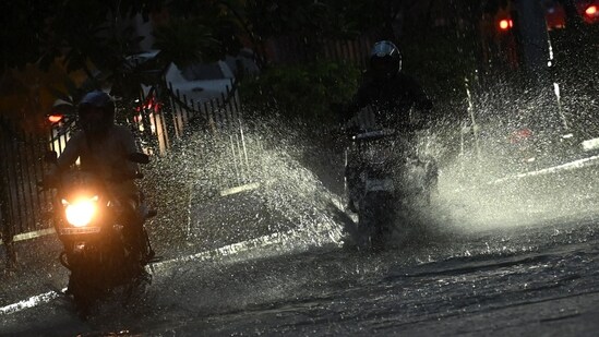 Motorists ride along a street amid torrential rain in New Delhi on July 15. Motorists ride along a street amid torrential rain in New Delhi on July 15.