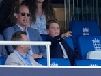 Britain's Prince George, right, reacts as he watches the play with his father Prince William .