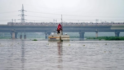Delhi Metro train passes above Yamuna river after heavy monsoon rains, in New Delhi, Monday. (PTI)