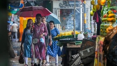 Pedestrians on a road during rain in Kolkata on Sunday. (PTI) Pedestrians on a road during rain in Kolkata on Sunday. (PTI)