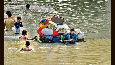 People carry their belongings at a flooded Yamuna Khadar in New Delhi on Sunday. (Sanjeev Verma/HT Photo) People carry their belongings at a flooded Yamuna Khadar in New Delhi on Sunday. (Sanjeev Verma/HT Photo)