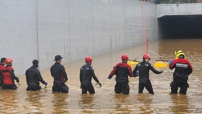 South Korea Rainfall: South Korean rescue workers searching for missing persons along a deluged road. (AFP) South Korea Rainfall: South Korean rescue workers searching for missing persons along a deluged road. (AFP)