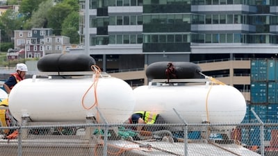 People inspect the Polar Prince ship and the deployment barge, used with the Titan submersible that imploded while carrying five people to explore the wreck of the sunken Titanic, as the Transportation Safety Board of Canada begins its investigation into the loss of the submersible from OceanGate Expeditions, at St. John's harbour, Newfoundland, Canada. (REUTERS)