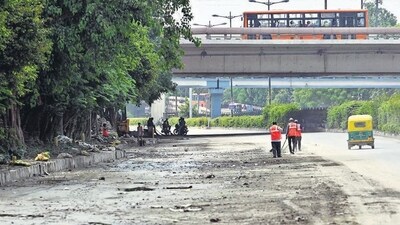 Workers clean the road in front of Monastery Market, in New Delhi on Sunday. (Vipin Kumar/HT)