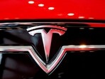 A Tesla logo on a Model S is photographed inside of a Tesla dealership.