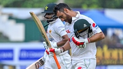 Agha Salman (R) and Saud Shakeel walk back to the pavilion after rain stopped the play during the second day of the first cricket Test match between Sri Lanka and Pakistan (AFP) Agha Salman (R) and Saud Shakeel walk back to the pavilion after rain stopped the play during the second day of the first cricket Test match between Sri Lanka and Pakistan (AFP)
