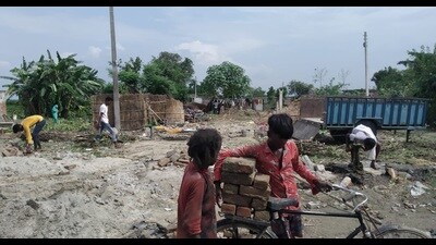 Children assisting their parents in carrying the building material remains at Ahirana village after the erosion by Sharda forced them to demolish houses. (HT PHOTO)