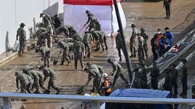 Photos from the scene showed fire and police officers using search dogs while wading through knee-high mud and debris from destroyed homes. (AFP) Photos from the scene showed fire and police officers using search dogs while wading through knee-high mud and debris from destroyed homes. (AFP)