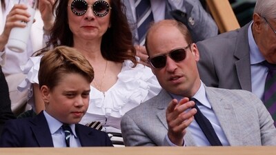 Britain's Prince George and Britain's Prince William, Prince of Wales in the royal box during the men's singles final (REUTERS)