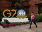 A man walks past a model of G20 logo outside the finance ministry in New Delhi.