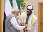 UAE President Sheikh Mohammed bin Zayed Al Nahyan ties an official COP 28 band with Prime Minister Narendra Modi at Abu Dhabi on Saturday.