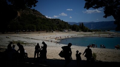 Bathers seek shade on the banks of the receding Sainte-Croix lake, southern France. Human-caused climate change is lengthening droughts in southern France, meaning the reservoirs are increasingly drained to lower levels to maintain the power generation and water supply needed for nearby towns and cities. French tourism, rafting and kayaking in fix as droughts worsen (AP Photo/Daniel Cole) Bathers seek shade on the banks of the receding Sainte-Croix lake, southern France. Human-caused climate change is lengthening droughts in southern France, meaning the reservoirs are increasingly drained to lower levels to maintain the power generation and water supply needed for nearby towns and cities. French tourism, rafting and kayaking in fix as droughts worsen (AP Photo/Daniel Cole)