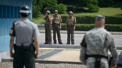 North Korean soldiers (C) take photos towards a South Korean soldier (L) and a US soldier (R) standing before the military demarcation line (lower C) separating North and South Korea within the Joint Security Area (JSA) at Panmunjom. (AFP) North Korean soldiers (C) take photos towards a South Korean soldier (L) and a US soldier (R) standing before the military demarcation line (lower C) separating North and South Korea within the Joint Security Area (JSA) at Panmunjom. (AFP)