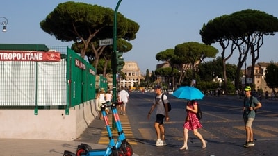 Visitors cross the street during hot weather caused by the Charon heat wave, in Rome, Italy. (Bloomberg) Visitors cross the street during hot weather caused by the Charon heat wave, in Rome, Italy. (Bloomberg)