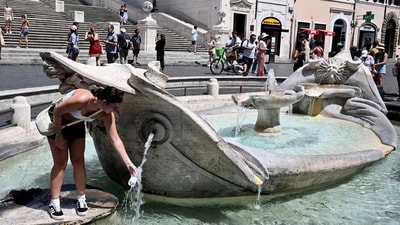 A woman fills a bottle with water at the Barcaccia fountain in front of the Scalinata di Trinita dei Monti (Spanish Steps) in Rome, during a heatwave in Italy. Unforgiving heat scorched parts of the Northern Hemisphere, triggering health warnings and fanning wildfires in the latest stark reminder of the effects of global warming. (Photo by Tiziana FABI / AFP) A woman fills a bottle with water at the Barcaccia fountain in front of the Scalinata di Trinita dei Monti (Spanish Steps) in Rome, during a heatwave in Italy. Unforgiving heat scorched parts of the Northern Hemisphere, triggering health warnings and fanning wildfires in the latest stark reminder of the effects of global warming. (Photo by Tiziana FABI / AFP)