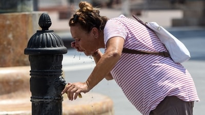A woman cools off in Skopje, on Tuesday, as Europe braces for record-smashing heat. (AFP)