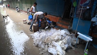Shopkeepers at the Tibetan Market in New Delhi can be seen cleaning their shops as the water levels of Yamuna gets lowered. (HT Photo/Sanchit Khanna)