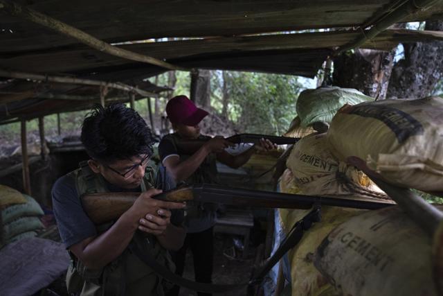 An armed tribal Kuki keeps a watch on rival Meitei community bunkers along a de facto frontline which dissects the area into two ethnic zones in Churachandpur, Manipur on Tuesday, June 20, 2023. (AP) An armed tribal Kuki keeps a watch on rival Meitei community bunkers along a de facto frontline which dissects the area into two ethnic zones in Churachandpur, Manipur on Tuesday, June 20, 2023. (AP)